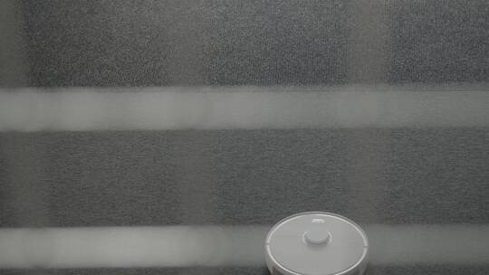 自动机器人吸尘器清洁地毯的大角度拍摄视频素材模板下载