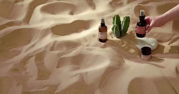 精油等护肤品放在沙地中广告摆拍