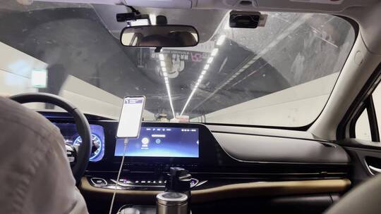 网约车司机按照手机上导航行驶在城市隧道
