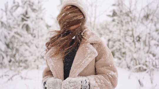 一个女人正在除掉头发上的雪