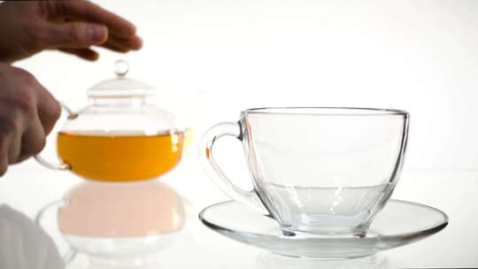 倒茶。茶倒入玻璃透明茶杯。喝茶时间。透明