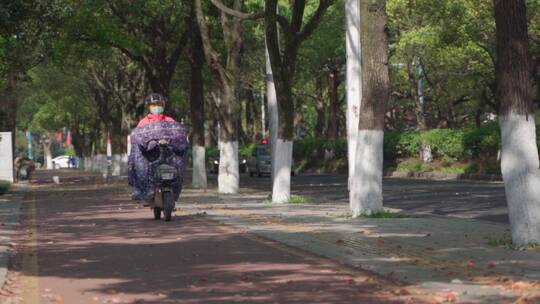 秋天街上骑电动车的市民