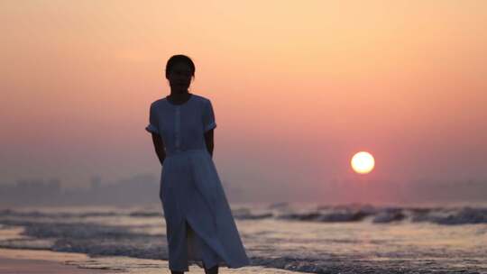 烟台夏天海边落日夕阳，女孩在沙滩上走动