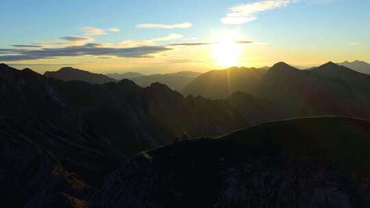 清晨阿尔卑斯山脉山顶的游客徒步旅行者