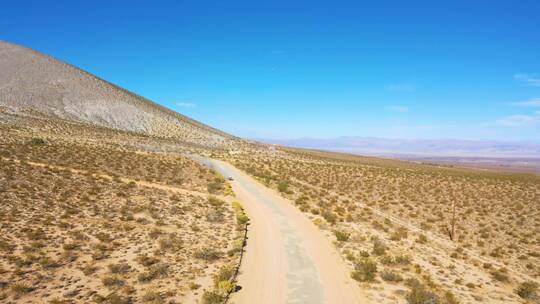 航拍行驶在沙漠土路上的越野车
