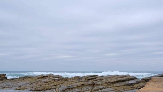 蓝天下海浪冲击着岸边的岩石视频素材模板下载