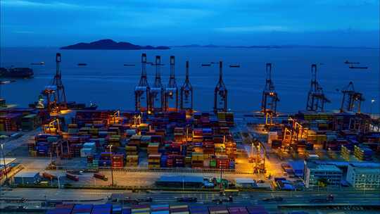 航拍傍晚蓝色大海和深圳蛇口港码头作业延时