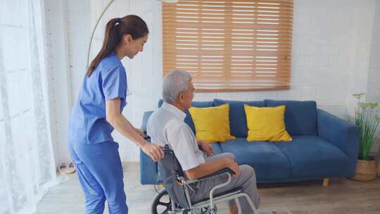 亚洲年轻的护理人员在家里照顾坐轮椅的老人
