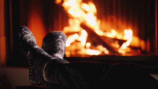 一个穿着袜子的人在壁炉旁烤火