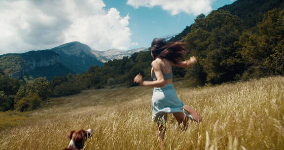 女孩与小狗在山间快乐的奔跑
