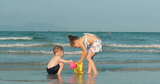 快乐无忧无虑的孩子们在海边玩沙子。孩子们玩耍，兄弟姐妹玩耍高清在线视频素材下载