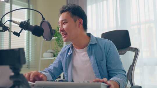 亚洲有吸引力的音频DJ男子对着麦克风说话广播。