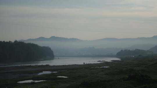 老蜂农挑着蜂箱领着孙子走在河边
