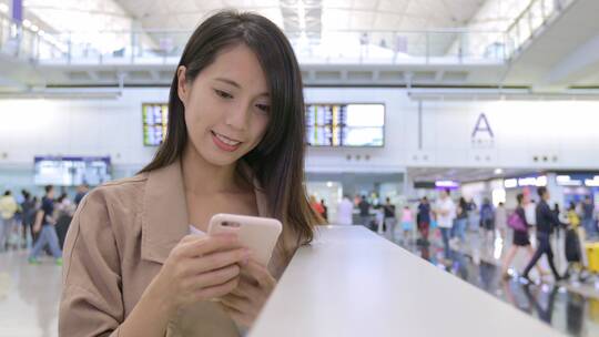 在机场使用手机的旅行妇女