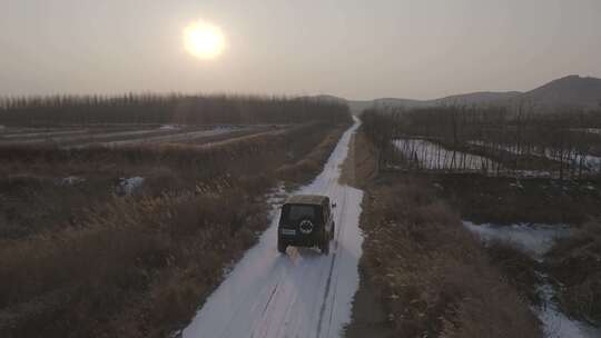 冬天吉普车行驶在北方乡村积雪白桦林小道