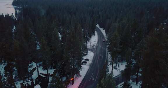 汽车在雪山附近的森林中行驶