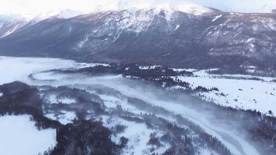 航拍新疆冬季喀纳斯河流晨雾雪山森林雪景