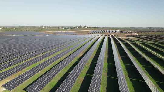 商业太阳能农场上的一排排太阳能电池板生产绿色能源；无人机