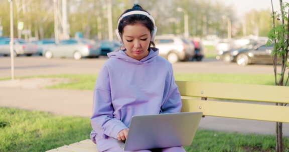 坐在公园里使用电脑的女孩