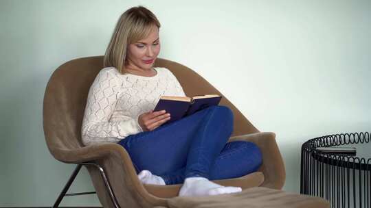 漂亮女人白天坐在家里的扶手椅上看书，做梦和享受