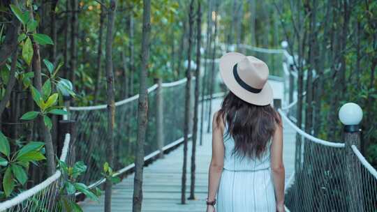 女人在山林中木栈道走路的背影