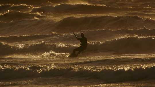 在夕阳西下，风筝冲浪享受风筝冲浪的自由和