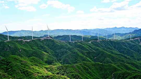 夏季绿色高山蓝天白云与风力发电机组