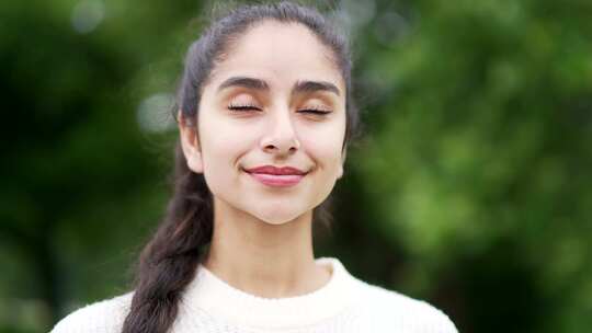 特写肖像年轻快乐的女人站在森林树木之间的
