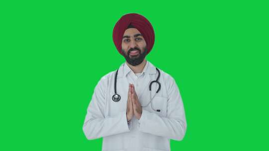 快乐的锡克教印度医生做合十礼绿屏