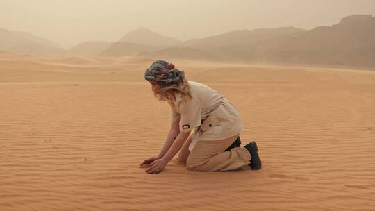女人在沙漠中扬沙