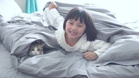 孩子与宠物猫在床上玩耍4k视频素材