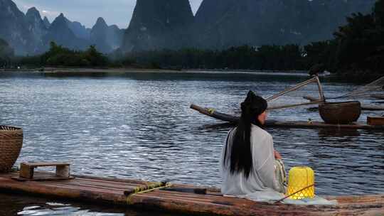 桂林漓江上的汉服小姐姐挑灯观察风景
