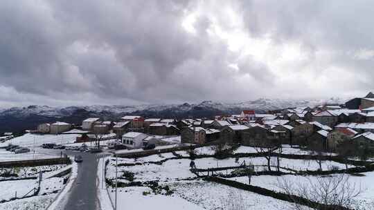 被雪覆盖的雪山斜坡上的山村建筑和房屋