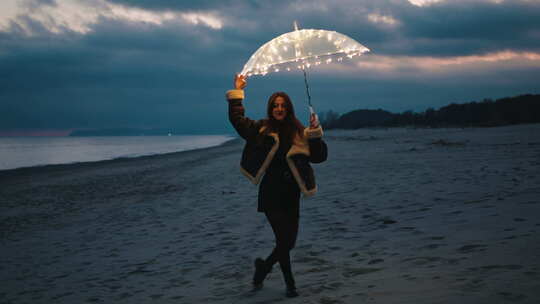 女孩在夜晚的海滩上拿着发光的雨伞跳舞