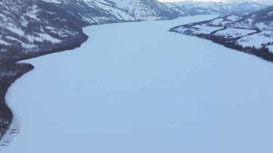 航拍新疆冬季喀纳斯河流晨雾雪山森林雪景