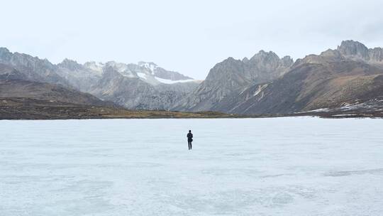航拍一人在结冰的姊妹湖上奔跑视频素材模板下载