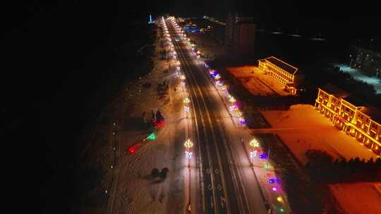 雪夜城市道路彩灯装饰的夜景航拍