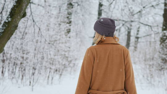 女人走过冬天的森林