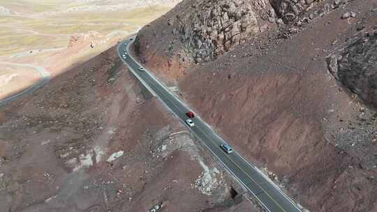 一辆红色越野车行驶在西藏的户外道路上