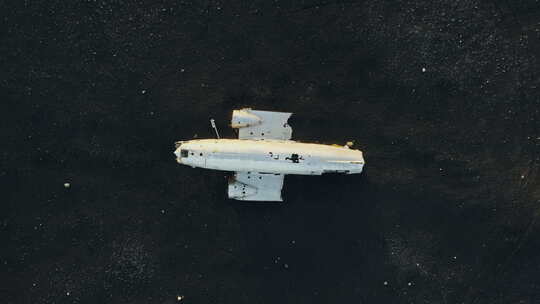 无人机驶向黑沙中的飞机残骸视频素材模板下载
