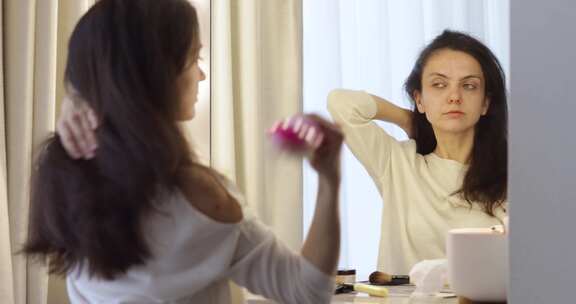 女人照镜子梳理健康的直发