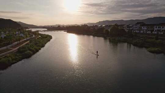 夕阳山村河流 年轻人划桨板