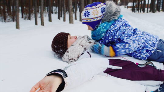 妈妈和女儿躺在雪地里玩耍