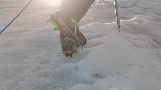 四川甘孜穿着冰爪攀登尼登贡嘎雪山的登山者