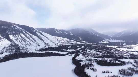 航拍新疆冬季喀纳斯湖雪景雪山森林冰河晨雾