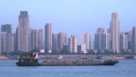 武汉江面上行驶的货船 城市高楼大厦背景