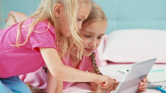 两个儿童使用平板电脑玩耍