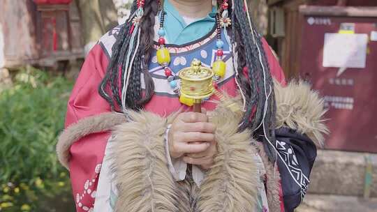 4K藏服女孩手持转经筒藏族饰品特写