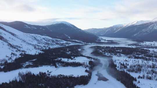 航拍新疆冬季喀纳斯河流晨雾雪山森林雪景