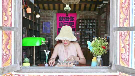 一位中国温柔美女女士坐在窗前用笔书写日记